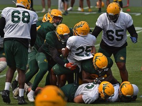 The contact level seems to be getting progressively higher for players as running back Walter Fletcher (25) gets tackled during Elks training camp at Commonwealth Stadium in Edmonton on Friday, July 16, 2021.