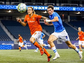 Alexander Achinioti-Jönsson (3) of Forge FC and Easton Ongaro of FC Edmonton (9) chase a loose ball at IG Field in Winnipeg on Wednesday, July 14, 2021.