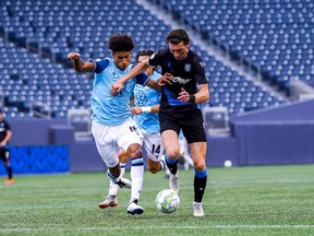 Kareem Sow of HFX Wanderers, left, and Easton Ongaro of FC Edmonton battle for the ball in Canadian Premier League play at Investors Group Field in Winnipeg on July 21, 2021.