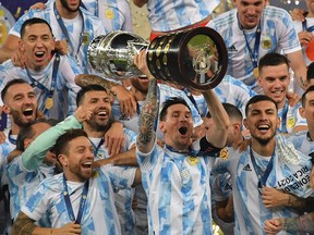 Argentina's Lionel Messi holds the trophy as he celebrates on the podium with teammates after winning the Conmebol 2021 Copa America at Maracana Stadium in Rio de Janeiro, Brazil, on July 10, 2021.