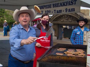 Alberta Premier Jason Kenney keeps a sharp eye on the prize as he shows off his pancake flipping skills at the annual Premier's Stampede Breakfast in downtown Calgary on Monday, July 12, 2021.