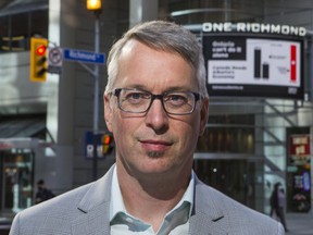 Bill Bewick, executive director of Fairness Alberta, stands by an electronic billboard promoting the importance the Alberta's economy to Ontario in Toronto on Sept. 21, 2020.