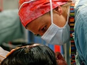 A nurse speaks with a patient at the University of Alberta Hospital in Edmonton. The Alberta government is proposing a three per cent rollback on salaries for nurses in the province.