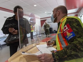 Capt. Kevin Little registers a community member for vaccination at the Nisichawayasihk Cree Nation clinic. Members of the Land Task Force support a COVID-19 vaccination clinic for the second dose in Nisichawayasihk Cree Nation in northern Manitoba during Operation VECTOR on May 7, 2021.