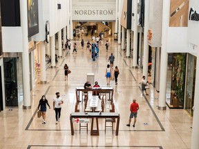 Shoppers carry bags while they walk inside Sherway Gardens mall during the stage two reopening from coronavirus disease (COVID-19) restrictions in Toronto, Ontario, Canada June 30, 2021.