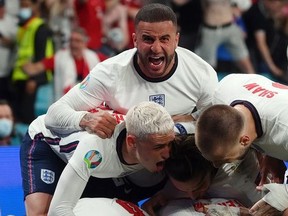 July 7, 2021 England's Harry Kane celebrates scoring their second goal with Kyle Walker and teammates.