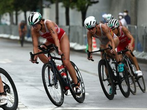Amelie Kretz, of Team Canada, rides ahead of Miriam Casillas Garcia, of Team Spain, and Barbara Riveros, of Team Chile, during the women's individual triathlon on Day 4 of the Tokyo 2020 Olympic Games at Odaiba Marine Park on July 27, 2021, in Tokyo, Japan.