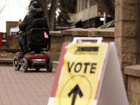 A man rides away on a motorized wheelchair after voting at a polling station at McKay Avenue School Archives and Museum at 10425 99 Avenue during the 2019 Federal Election in Edmonton, on Monday, Oct. 21, 2019.