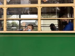 A young rider looks out the window of the Edmonton Radial Railway Society’s High Level Bridge Streetcar on a trip through Old Strathcona in Edmonton, on Sunday, Aug. 8, 2021.