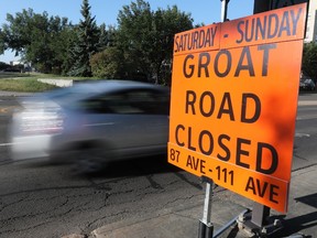 Traffic makes its way past road closure signs set up for this weekend's 2021 World Triathlon Championships in Edmonton on Friday, Aug. 20, 2021.