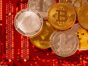 Dalam ilustrasi yang diambil pada 29 Juni 2021 ini, mata uang virtual Bitcoin, Ethereum, Dogecoin, Ripple, dan Litecoin ditempatkan pada motherboard PC.