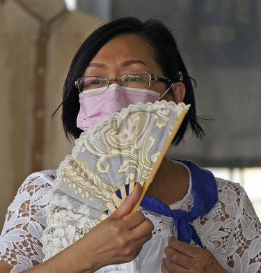 Christy Raspado tries to keep cool with a hand held fan at the Edmonton Heritage Festival held in Hawrelak Park on Saturday July 31, 2021 as temperatures soared to over 30C degrees.