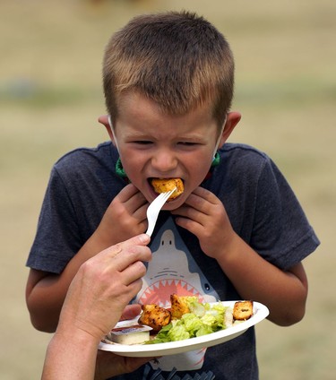 A boy chows down during the Edmonton Heritage Festival in Hawrelak Park on Sunday August 1, 2021.