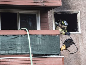Firefighter remove debris from a suite in Commonwealth Place  on 93 Street and 105a Ave. on August 3,  2021. Two occupants were rescued and sent to hospital for observation.