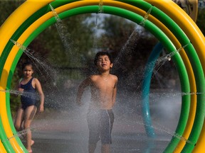 Children stay cool in the spay park at Jackie Parker Park as temperatures reached 27 C on Tuesday, Aug. 3, 2021 in Edmonton.
