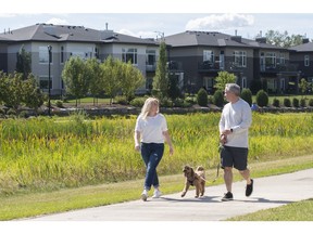 Jennifer and Dino Cairo walk their dog, Cooper, in the neighbourhood of their soon-to-be-built home in Drive at Windermere.