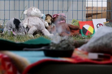 Children's stuffed animals lean against a construction fence during a protest on the grounds of the former Charles Camsell Indian Hospital, in Edmonton Monday Aug. 9, 2021. The protesters hope to bring awareness to the discovery of over 5,000 unmarked graves at Canada's former residential school sites. Over nearly 50 days the nightly protest has hosted healers, drummers, speakers, survivors and singers. Part of the hospital site was recently searched for unmarked graves and future searches are planned.