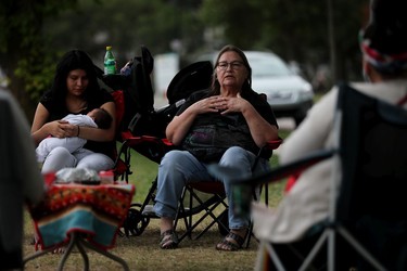 Laura Morin talks about being born at the former Charles Camsell Indian Hospital and the medical treatment she received, including the birth of three children, at later versions of the hospital, during a protest on the grounds of the former Charles Camsell Indian Hospital, in Edmonton Monday Aug. 9, 2021. The protesters hope to bring awareness to the discovery of over 5,000 unmarked graves at Canada's former residential school sites. Over nearly 50 days the nightly protest has hosted healers, drummers, speakers, survivors and singers. Morin's three week-old great grandson Micah Mindus-Morin is held by his mother Claudine Mindus. Part of the hospital site was recently searched for unmarked graves and future searches are planned.