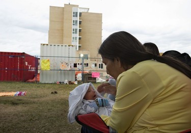 Three week-old Micah Mindus-Morin is comforted by his great grandmother Doreen Mindus during a protest on the grounds of the former Charles Camsell Indian Hospital, in Edmonton Monday Aug. 9, 2021. The protesters hope to bring awareness to the discovery of over 5,000 unmarked graves at Canada's former residential school sites. Over nearly 50 days the nightly protest has hosted healers, drummers, speakers, survivors and singers. Part of the hospital site was recently searched for unmarked graves and future searches are planned.