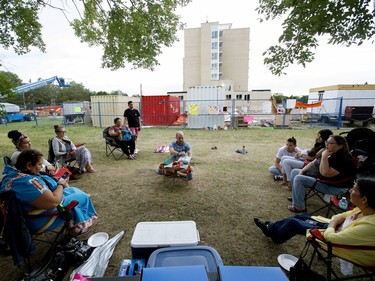 Laura Morin, second from the right, talks about being born at the former Charles Camsell Indian Hospital and the medical treatment she received, including the birth of three children, at later versions of the hospital (visible in the background), during a protest on the grounds of the former Charles Camsell Indian Hospital, in Edmonton Monday Aug. 9, 2021.