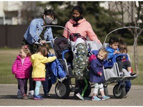 Two daycare workers take a group of children out for a walk in west Edmonton on Thursday May 6, 2021.