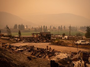 Thick smoke fills the air and nearly blocks out the sun as a property destroyed by the White Rock Lake wildfire is seen in Monte Lake, east of Kamloops, on Saturday, August 14, 2021.