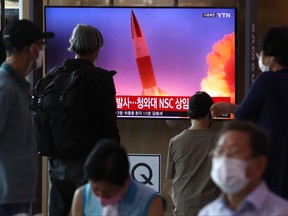 People watch a TV at the Seoul Railway Station on Wednesday showing a file image of a North Korean missile launch. Wednesday's missiles were fired from central inland areas of the North.