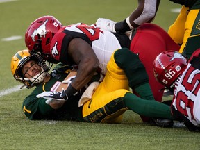 Edmonton Elks’ quarterback Trevor Harris (7) is sacked by Calgary Stampeders’ Shawn Lemon (40) during first half CFL football action at Commonwealth Stadium in Edmonton, on Saturday, Sept. 11, 2021.