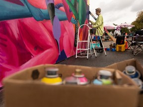 Ariel Durkin works on a colaborative piece with Peter Gegolgick called U and Me during Grindstone’s Mural Massive Block Party + Art Auction outside of Grindstone Theatre in Edmonton on Sept. 12, 2021.