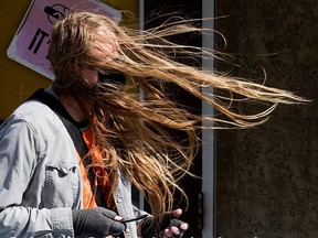 A transit rider is buffeted by the wind as they wait for a bus near 86 Avenue and 109 Street in Edmonton, Thursday Sept. 16, 2021. Photo by David Bloom