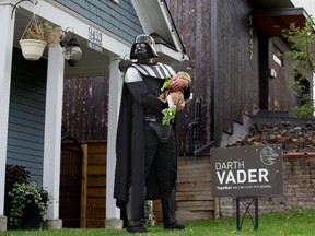 Darth Vader (Marty Pawlina) and Baby Yoda (his 2 month-old daughter Aria Pawlina) pose for a photo in front of the election lawn sign in front of their Edmonton home, Friday Sept. 17, 2021. Pawlina, who made the election sign himself, said his campaign platform was, 'There is still some good left in him' and "I am altering the deal. Pray I don't alter it any further." Photo by David Bloom