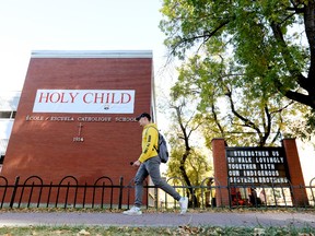 A pedestrian makes their way past the newly renamed Holy Child Elementary School, 9844 110 St., in Edmonton  on Wednesday Sept. 29, 2021. Edmonton Catholic Schools renamed the school which was formerly named Grandin Catholic Elementary. Bishop Vital-Justin Grandin was an advocate for the Indigenous residential school system.