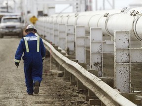 A worker walks along a new pipeline at the Enbridge facility in the east of Edmonton. File photo.