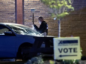 Police investigate the scene of a crash that injured 7 people after a woman lost control of her car in a parking lot at the Sunshine Academy polling station in Montreal, on Sept. 20, 2021.