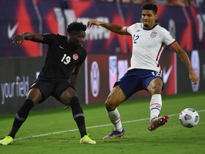 Canada midfielder Alphonso Davies (19) plays the ball past United States defender Miles Robinson (12) in the first half during a CONCACAF FIFA World Cup Qualifier soccer match at Nissan Stadium on Sept. 5, 2021.