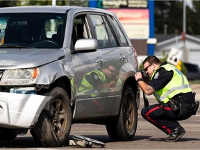 Edmonton Police Service officers investigate after two seniors were sent to hospital in a hit-and-run collision by Honda that hit a Suzuki Grand Vitara at 50 Street at 101 Avenue in Edmonton on Friday, Sept. 10, 2021. The intersection was closed during the investigation.
