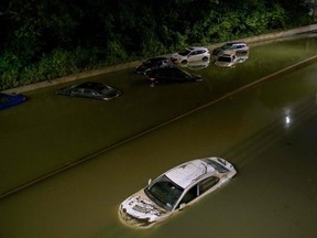 Floodwater surrounds vehicles following heavy rain on an expressway in Brooklyn, New York early on September 2, 2021, as flash flooding and record-breaking rainfall brought by the remnants of Storm Ida swept through the area.