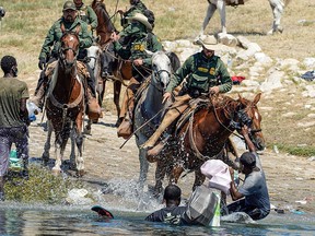 A Border Patrol agent on horseback knocks a Haitian migrant back into the Rio Grande River near the Acuna Del Rio International Bridge in Del Rio, Texas on September 19, 2021.
