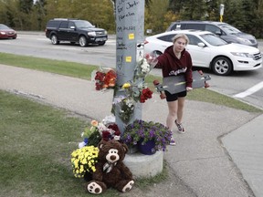 A memorial with flowers has been erected at the intersection of Jennifer Heil Way and Spruce Ridge Road on Sunday, Sept. 26, 2021 in Spruce Grove, AB, after a 25-year-old man was killed in a hit-and-run on Friday.