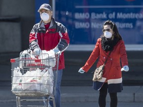 A couple wearing masks leave Markham’s Denison Centre with groceries during the ongoing pandemic, Wednesday April 1, 2020.