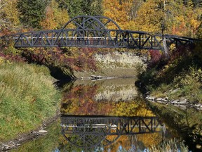 The fall colours and the pedestrain bridge reflected in the water of Whitemud Creek in Edmonton, September 27, 2021. Ed Kaiser/Postmedia