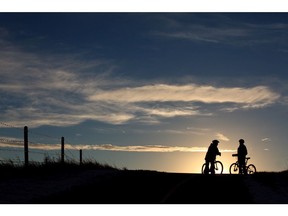 Silhouette of two bikers at sunset in Fish Creek Provincial Park.
