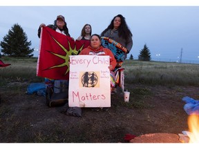 Lyndsay Breadner, left, Trinity Brandon-DeMeuse, Lorelei Mullings and Andrea Jenkins take part in an unmarked graves vigil for children of residential schools on Friday, Sept. 10, 2021 in Edmonton.
