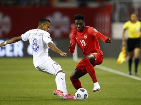 Alphonso Davies (19) of Canada battles for the ball against Edwin Rodriguez (8) of Honduras during their 2022 World Cup qualifying match at BMO Field on Sept. 2, 2021, in Toronto.