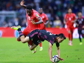 Alphonso Davies of Canada battles for possesion with Hirving Lozano of Mexico during the match between Mexico and Canada as part of the Concacaf 2022 FIFA World Cup Qualifier at Azteca Stadium on October 07, 2021 in Mexico City, Mexico.