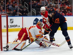 Edmonton Oilers’ Leon Draisaitl (29) is stopped by Calgary Flames goaltender Jacob Markstrom (25) during first period NHL action at Rogers Place in Edmonton, on Saturday, Oct. 16, 2021.