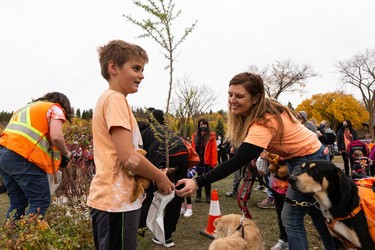 (Left to right) Kazim, 9, Sarika, 6, Ania Telfer and their dogs Zilo, 2, and Youki, 7, choose plants during the Roots for Trees Plant Giveaway at Hawrelak Park in Edmonton, on Thursday, Sept. 30, 2021. Edmontonians were invited to pick up a plant, speak with an Elder and plant their tree or plant as an act of reconciliation on National Day of Truth and Reconciliation.