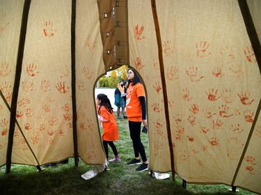 Participants painted a tipi covering it with their orange handprints on the first National Day for Truth and Reconciliation at the Westridge Community Park where they held teachings, drumming, and songs in Edmonton, September 30, 2021.