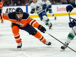 Edmonton Oilers' Cody Ceci (5) battles Vancouver Canucks' Jason Dickinson (18) during the second period of preseason NHL action at Rogers Place in Edmonton, on Thursday, Oct. 7, 2021. Photo by Ian Kucerak