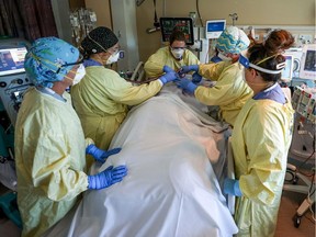 A health-care team in the Red Deer Regional Hospital intensive care unit move a COVID patient into the prone position which can help with oxygen flow to the lungs of the patient.